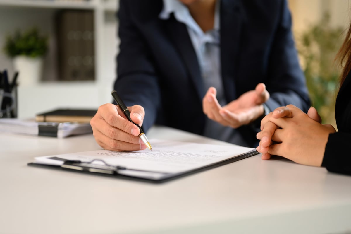 Two professionals finalizing a legal deal at a modern office desk