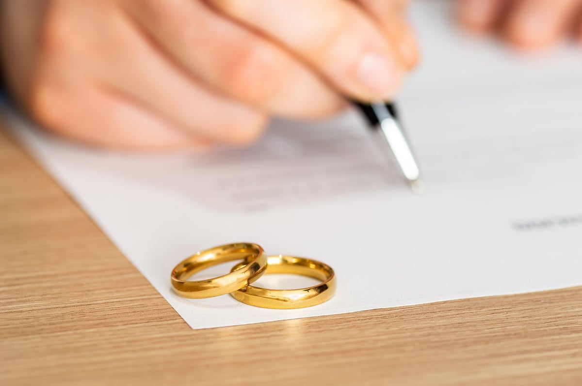 Divorce rings and signature on paperwork for legal documents
